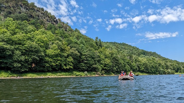 A kayak floating down the river under a clear blue sky.