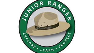 Junior Ranger Logo of ranger hat in a circle with the words junior ranger above and explore below 