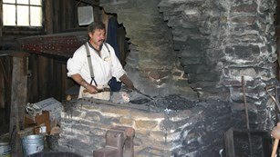 Blacksmith at work at the furnace