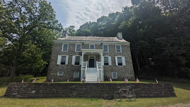 A 1700s stone house set up on a hill.