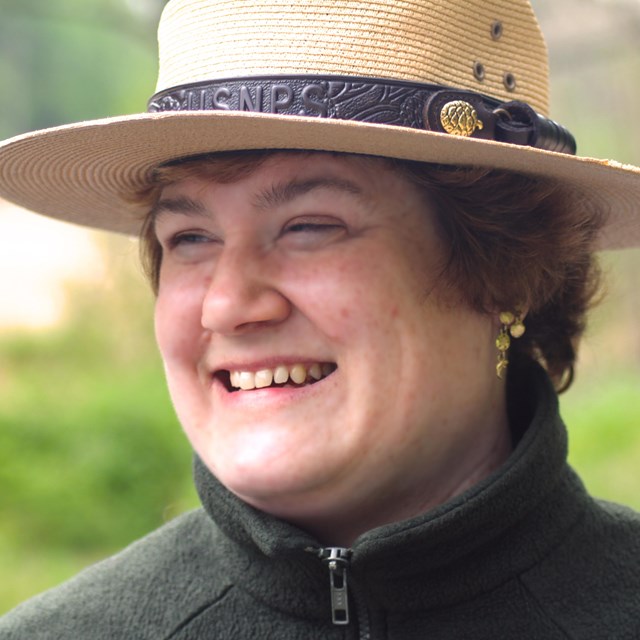 A smiling ranger wears her traditional Campaign or 