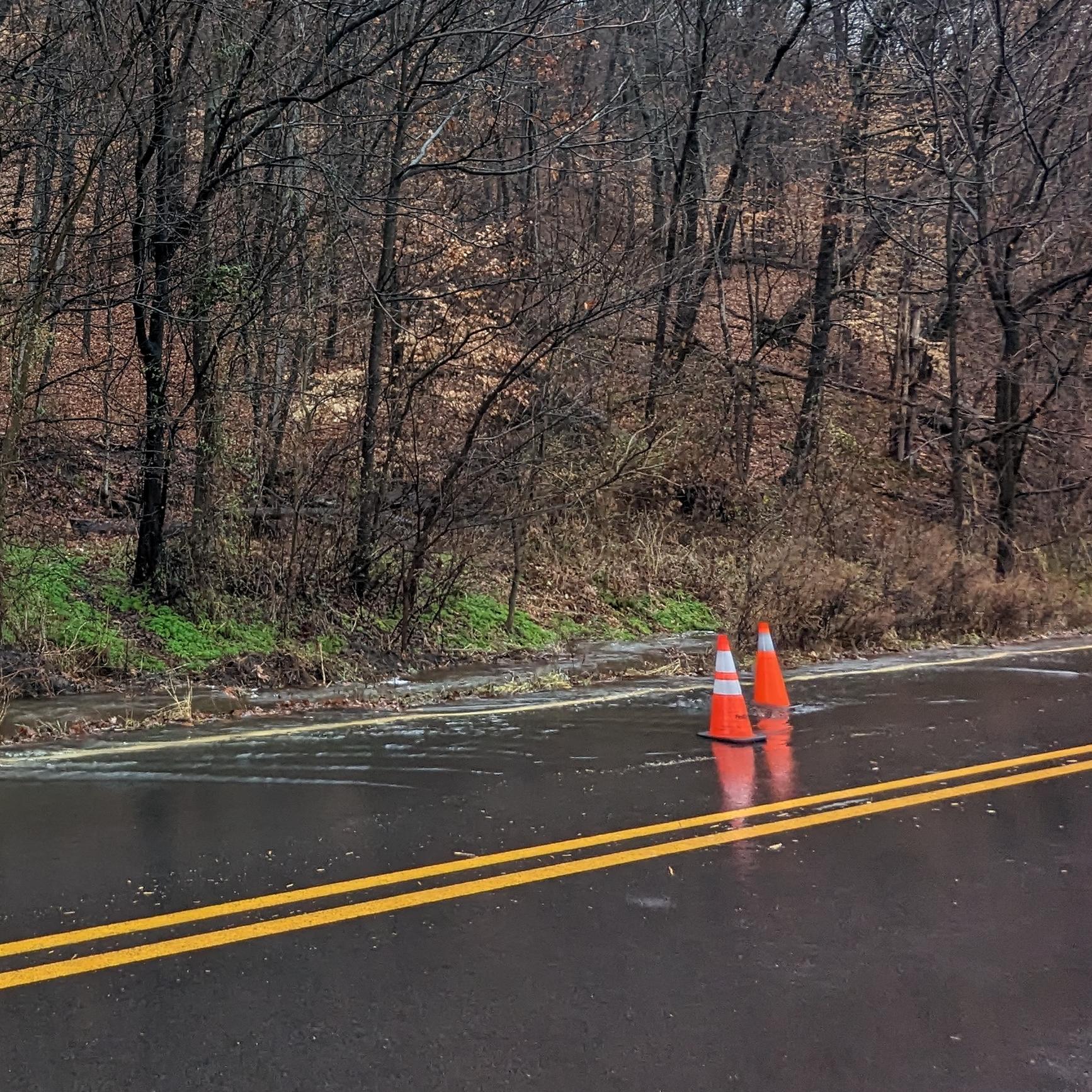 Mountain runoff creating a waterfall and roadway flooding.