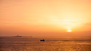 A boat passes by the Dry Tortugas with Loggerhead Key in background.