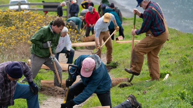 Group of people work on maintenance of trail.