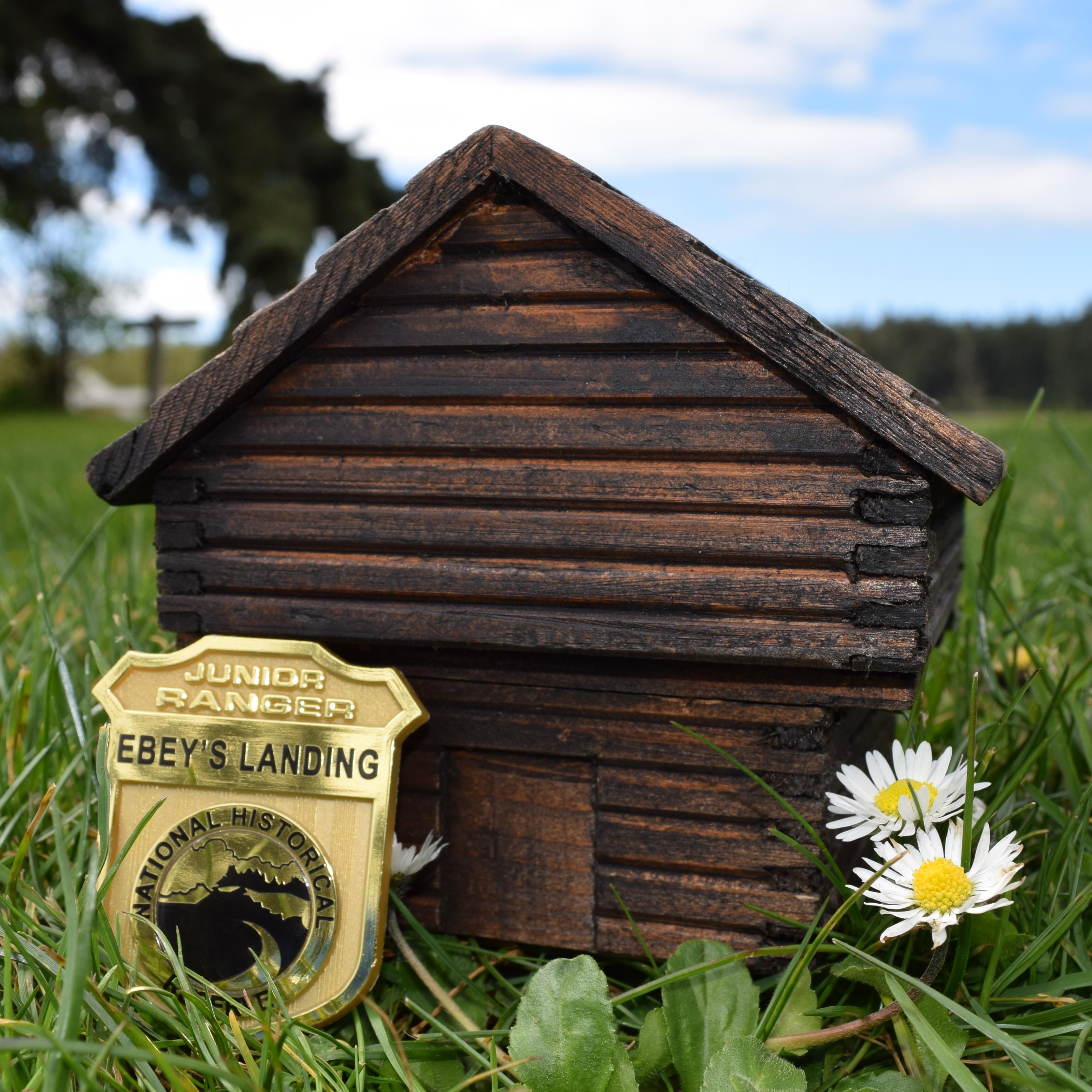 Jr Ranger badge in front of replica block house.