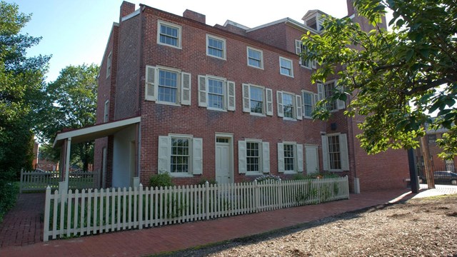 Exterior photo of the Edgar Allan Poe National Historic Site, a three-story brick building. 