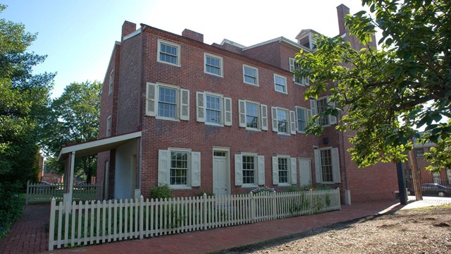 Exterior photo of the Edgar Allan Poe National Historic Site, a three-story brick building. 