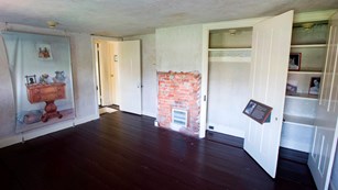 Color photo of an unfurnished room with a wall mural depicting a table.