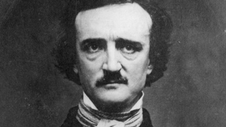 Black and white photo of a man with dark hair, high forehead, and bushy mustache and eyebrows.