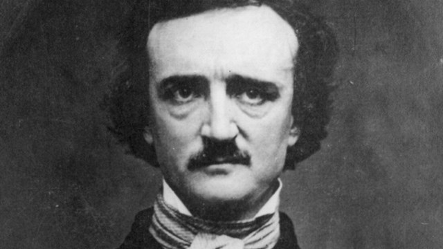 Black and white photo of a man with dark hair, high forehead, and bushy mustache and eyebrows.