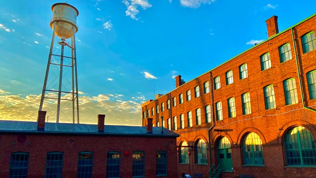 Long rectangular one story red brick building. sky in background