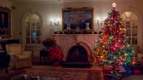 The Eisenhower home is decorated for Christmas with a lit Christmas tree and many other items.
