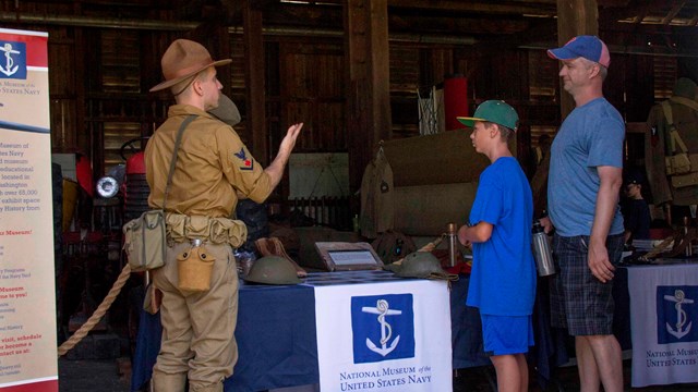An image showing a volunteer in World War I attire speaking to park visitors. 