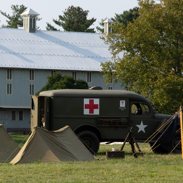 United States Army Medical Van in and tents in front of Eisenhower Show Barn.