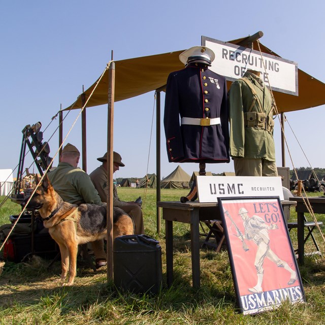 A color image showing a living history tent with USMC recruiting posters in front