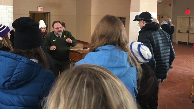 A park ranger use his hands to demonstrate his story.