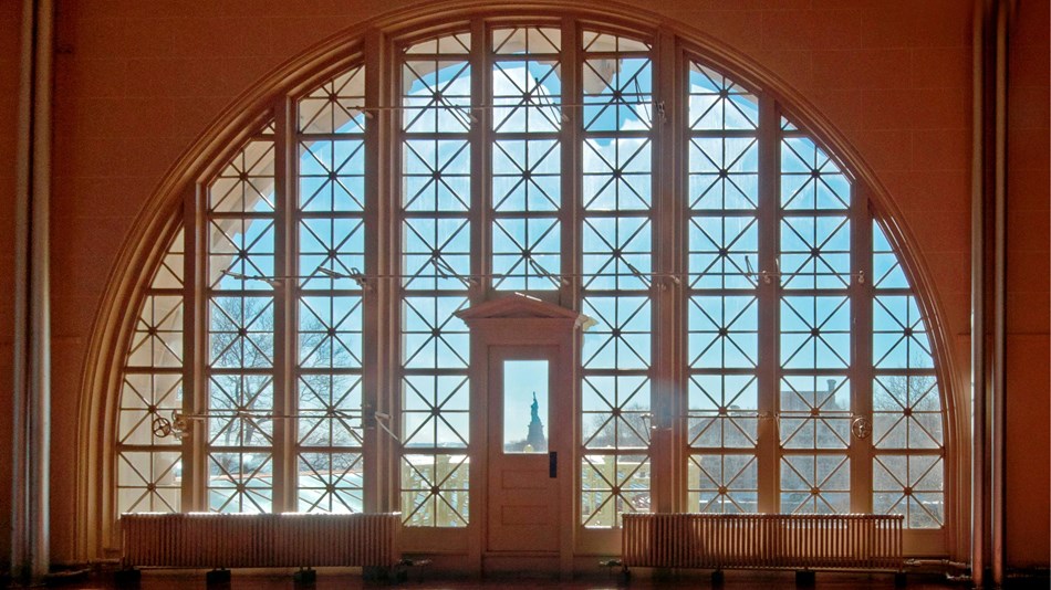 In the Great Hall of Ellis Island, looking through one of the windows towards the Statue of Liberty.