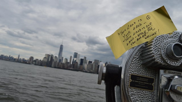  Paper gold brick on telescope with message from visitor looking at New York Harbor.