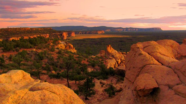 Yellow sandstone takes on a pinkish hue at sunset with sandstone cliffs and a lavender sky at sunset