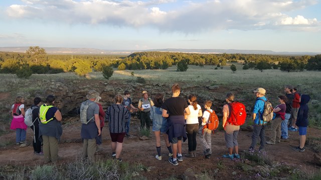 Visitors on a trail watching a ranger-led program. 