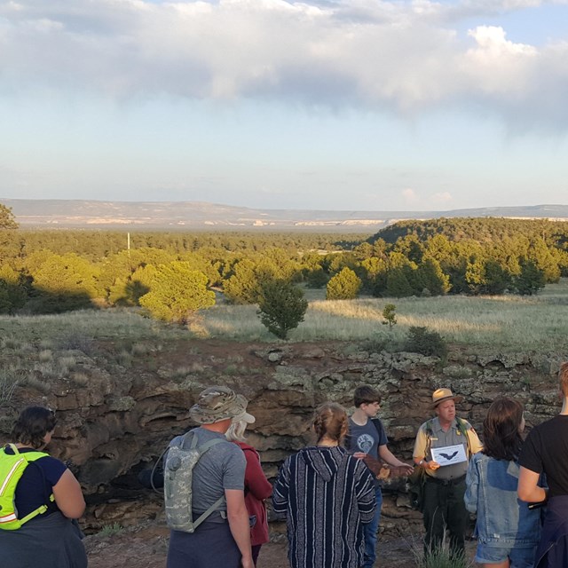 Visitors on a trail watching a ranger-led program. 