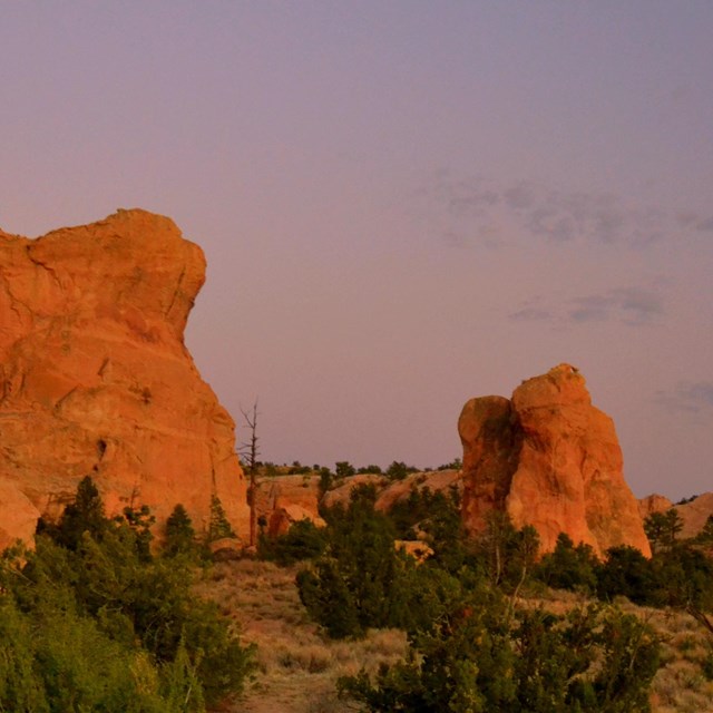 Red sandstone outcrops rise above a desert landscape