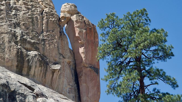 A rock spire next to a cliff face