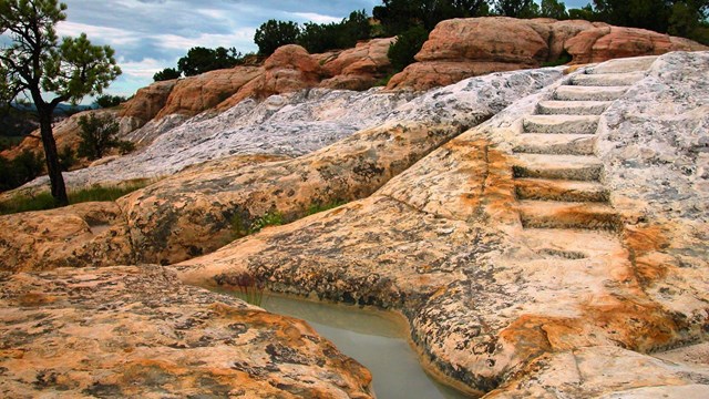 Stairs carved into a rock surface, marking a trail.