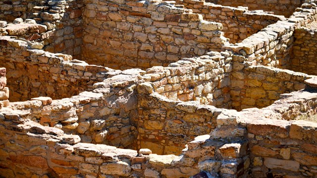 Stone walls that show multiple rooms of a pueblo.