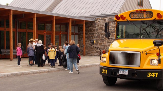 Children exiting a school bus to enter a visitor center.