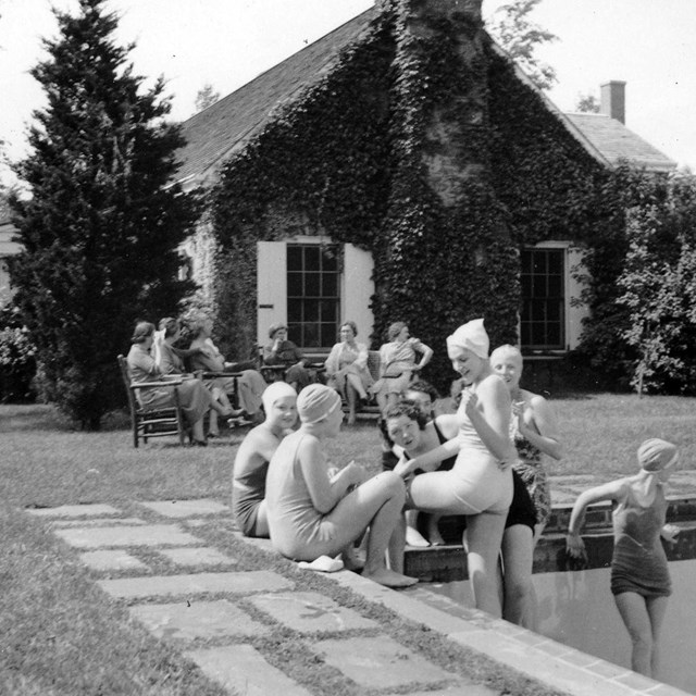 A group of young women gathered around a swimming pool.
