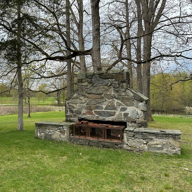 A large stone fireplace with chimney.