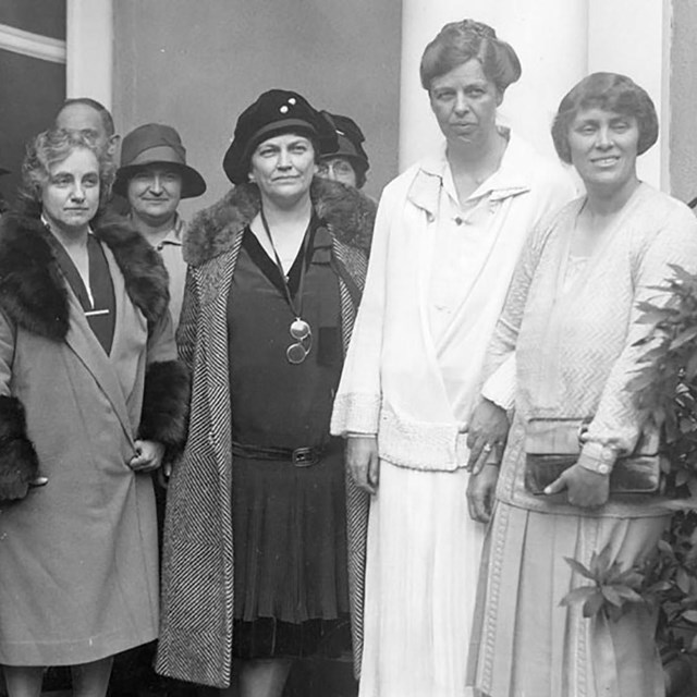 A group of women standing near a building.