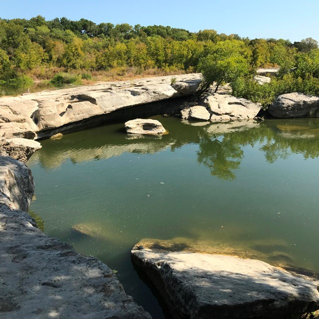 A waterfall over a large rock ledge.