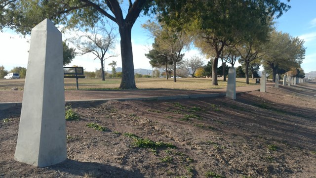 Se extiende una línea de obeliscos de hormigón a la orilla de un sendero.