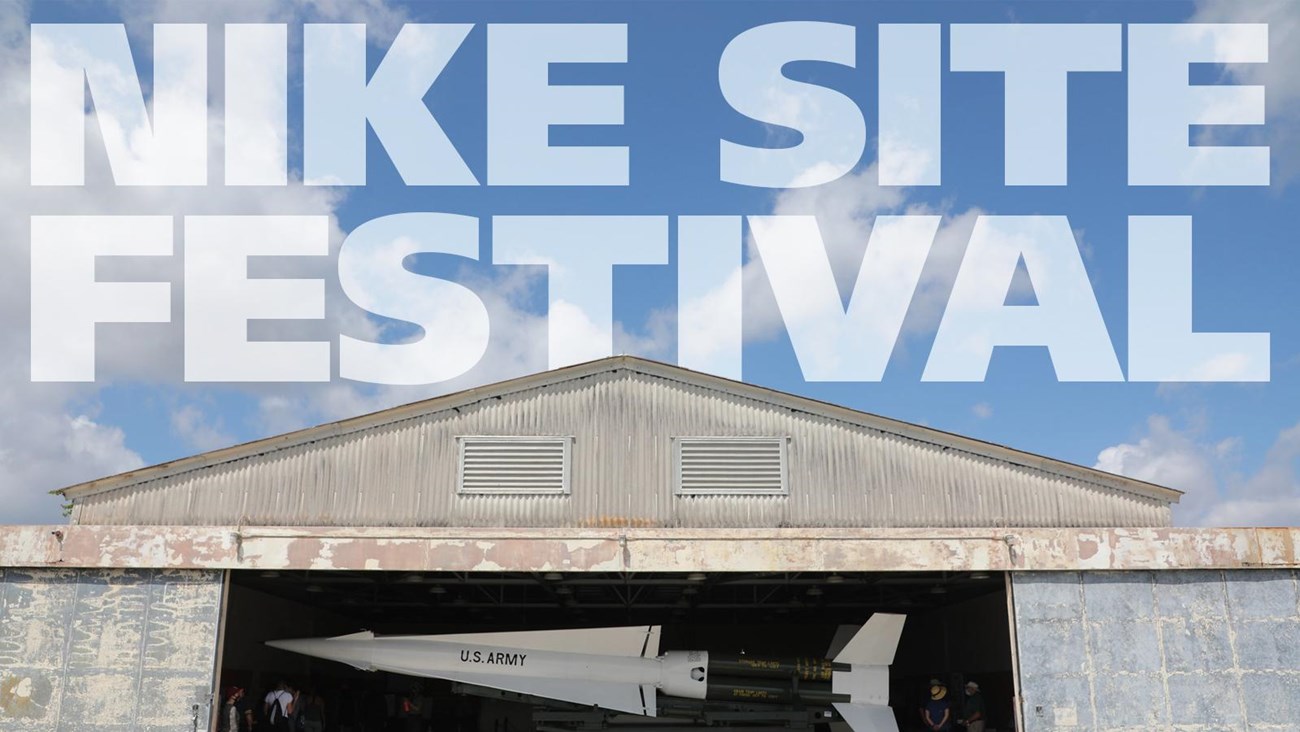 A barn door with a Hercules Missile and the words Nike Site Festival on top in the sky. 