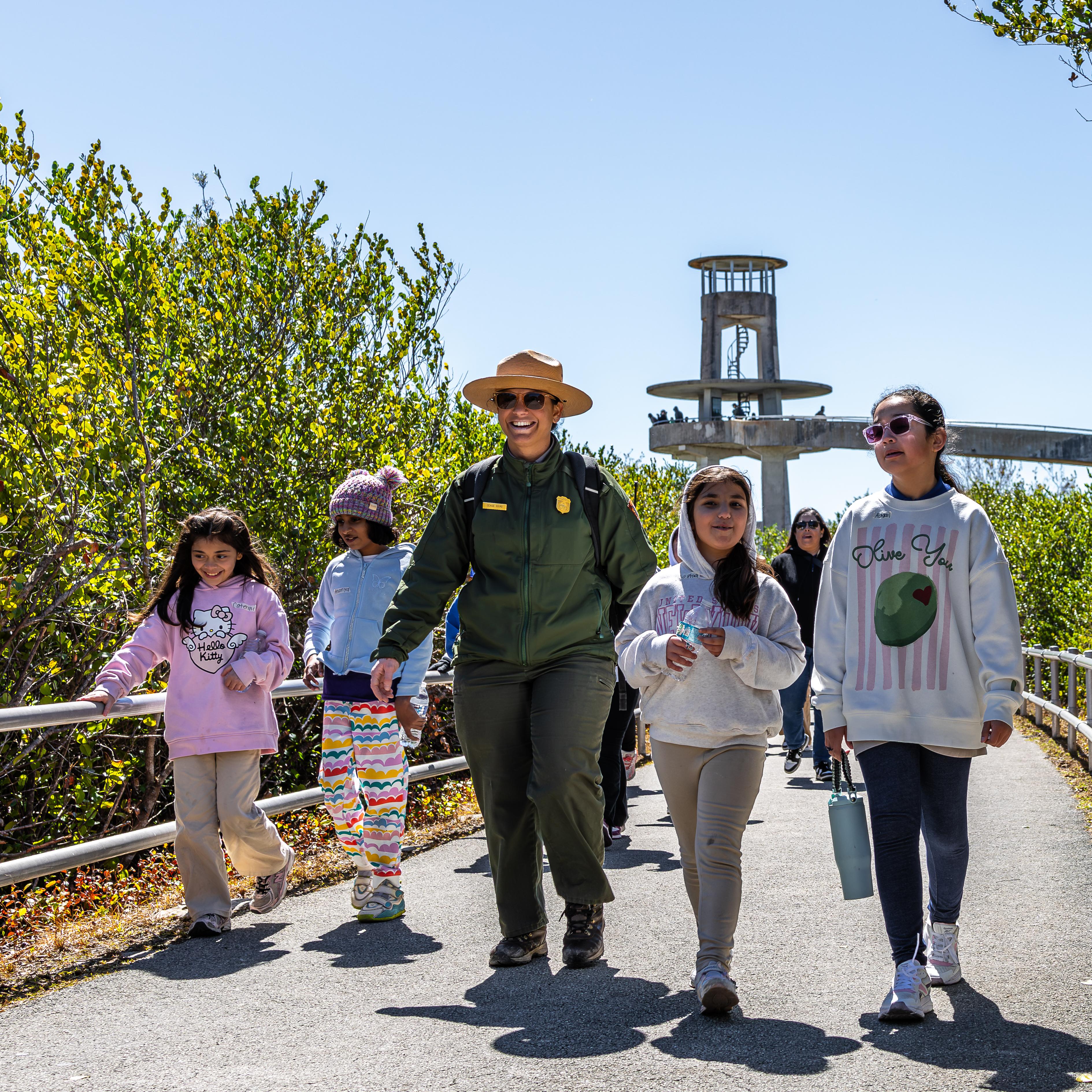 Park ranger smiling at camera with students. 
