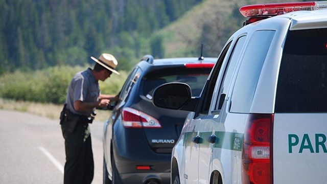 law enforcement ranger pulls over a visitors car, police ranger vehicle is also visible