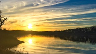 Sunset over a lake lined with trees