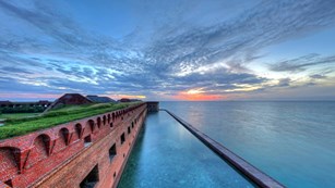 sunrise view of a brick front and the blue ocean 