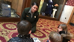 Ranger sitting on the floor talking to kids