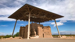 Two-story abobe house ruins underneath a large shelter structure