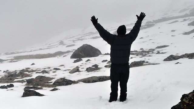 Visitor in the snow holding hands in the air