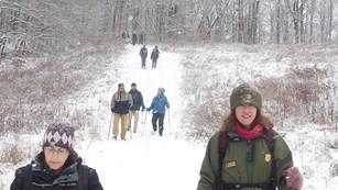Ranger and visitors on a trail covered in snow