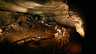 Underground image of people inside vast cave.