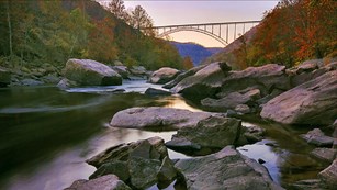 Arched steel bridge high above a river in a gorge