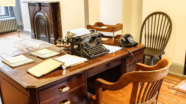 Desk covered with papers and a typewriter