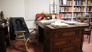 Office with a prominent desk, chair, and bookshelf