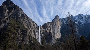 Water fall going down tall, steep cliff-face
