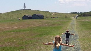 two kids running at an open field